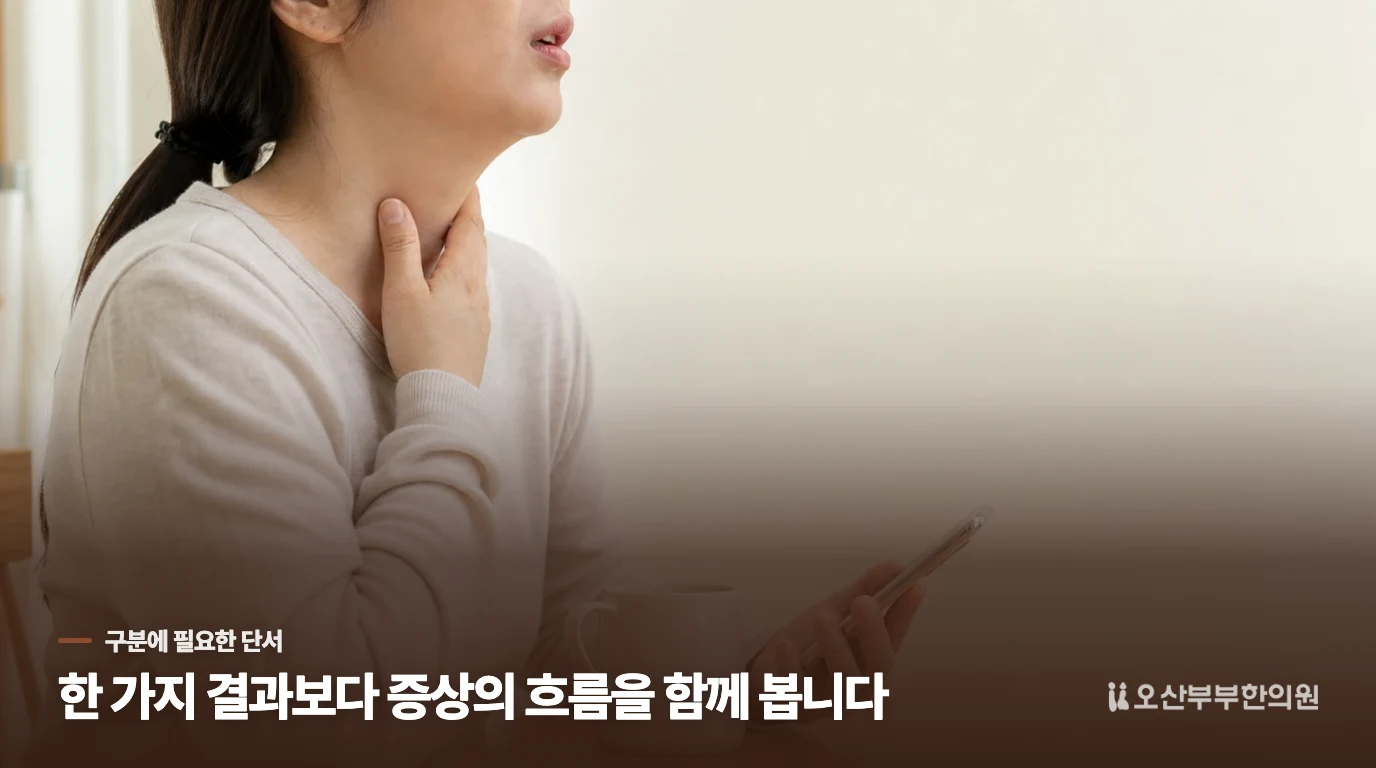 목의 불편을 표현하며 휴대전화를 들고 있는 근접 장면